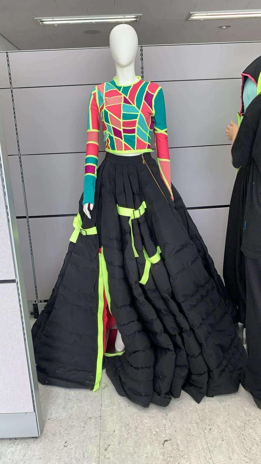 Look 01 on a mannequin in the studio: patchwork top and black quilted skirt