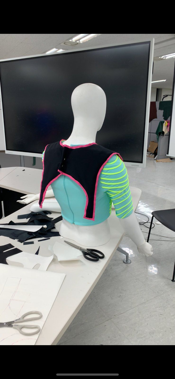 Phone screenshot of a mannequin wearing a cyan striped crop top